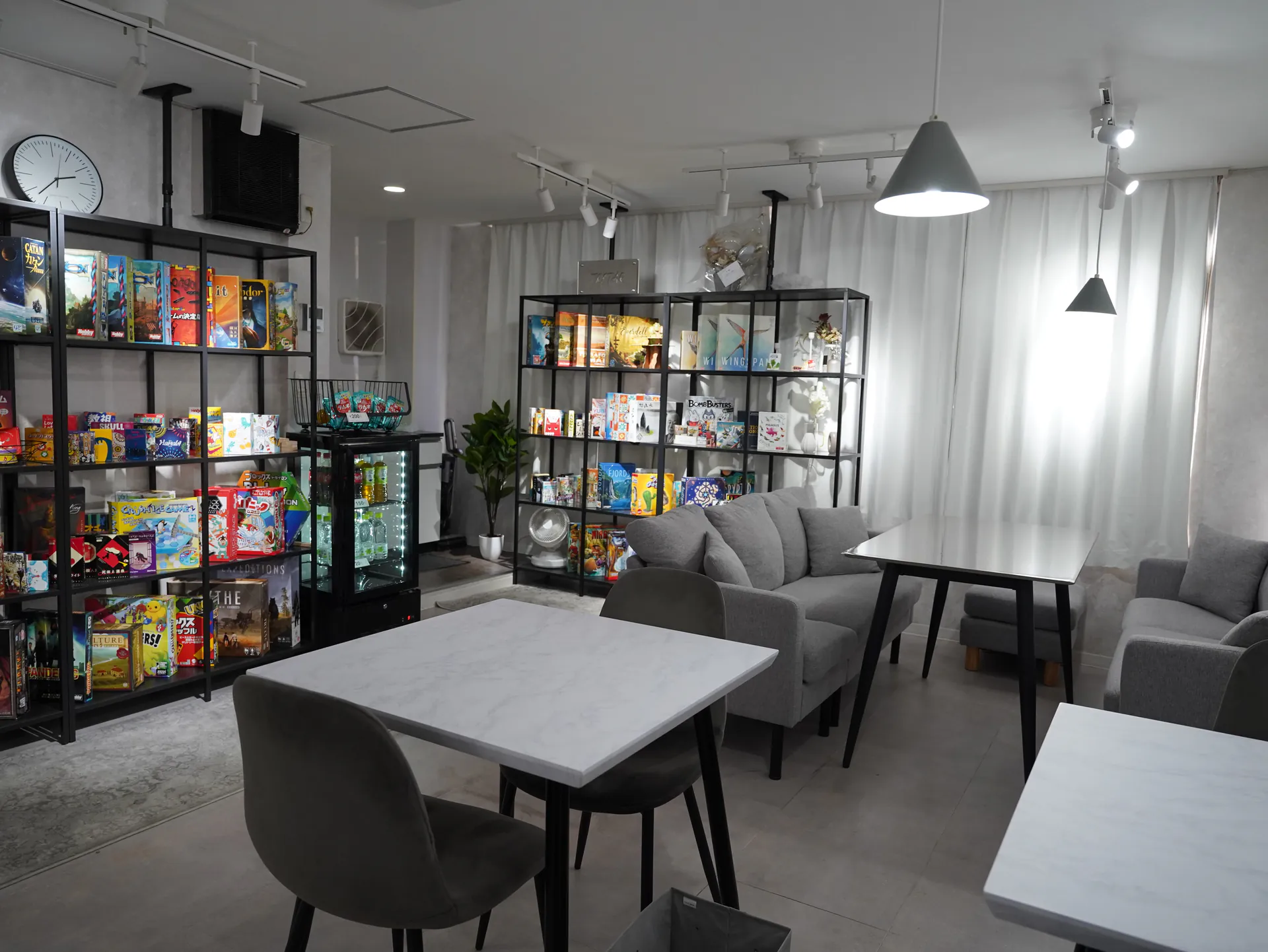 ボードゲームが並ぶ棚とゆったり座れるソファ席のある店内